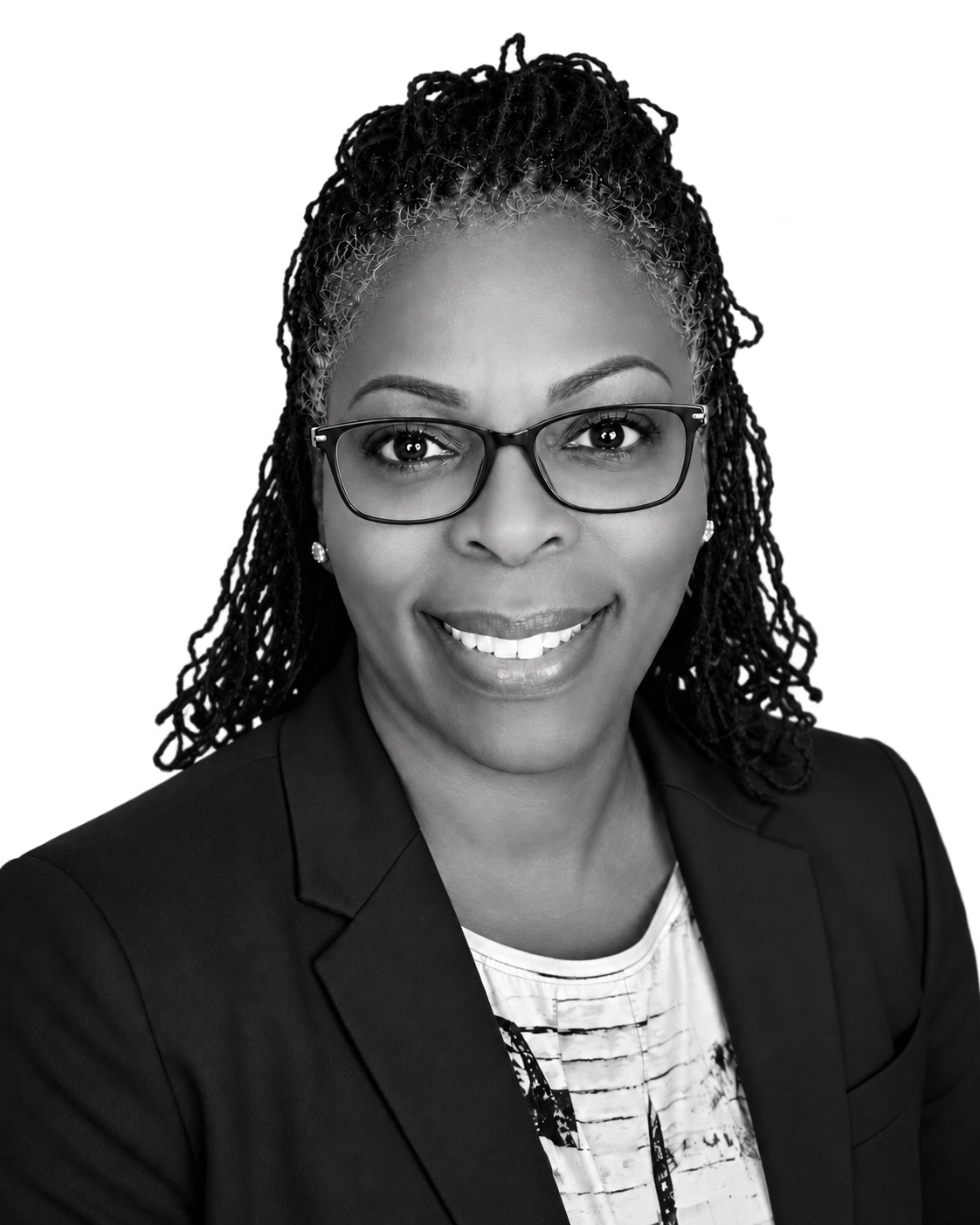 Stephanie Woods smiling, wearing glasses and a dark blazer
